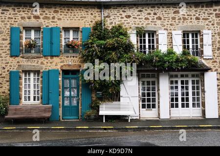 Edificio di mattoni con blu/bianco windows & decorato con fiori/verde Foto Stock