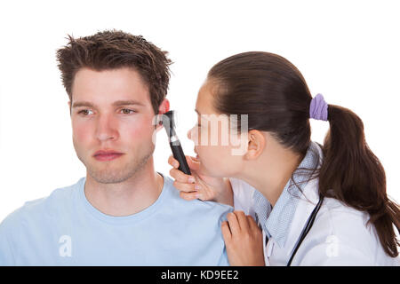 Close-up di un esame medico orecchio del paziente con un otoscopio Foto Stock