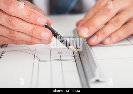 Close-up della persona del disegno a mano sul piano di stampa blu Foto Stock