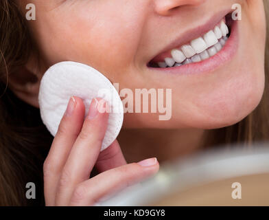 Ritratto di giovane donna detersione viso con cotone Foto Stock