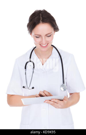 Ritratto di Felice medico donna Holding tavoletta digitale su sfondo bianco Foto Stock