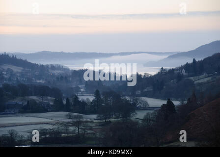 La mattina presto nebbia sopra Windermere in inverno con il gelo sul terreno, Lake District National Park, Regno Unito Foto Stock