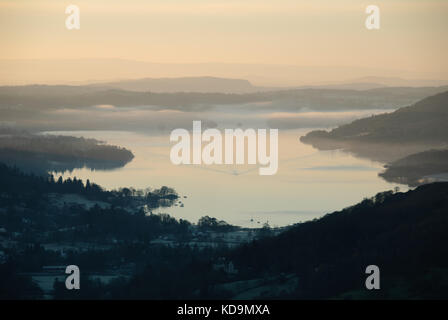 In barca che attraversa la nebbia mattutina su Windermere in inverno, Lake District National Park, Regno Unito Foto Stock