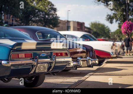 Una fila di auto americane classiche è parcheggiata in una piccola città del centro. Foto Stock