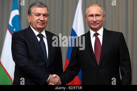 Sochi, Russia. 11 ottobre 2017. Il presidente russo Vladimir Putin saluta il presidente uzbeko Shavkat Mirziyoyev, partito, prima dell'inizio del loro incontro bilaterale a margine del vertice della CSI nella residenza di Bocharov Ruchei 11 ottobre 2017 a Sochi, Russia. Crediti: Planetpix/Alamy Live News Foto Stock