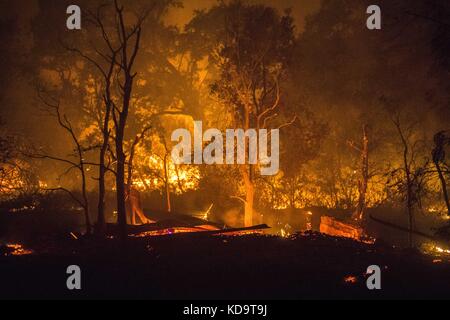 10 ottobre 2017 - Solano County/Napa County, CA, USA - UNA struttura brucia a terra al fuoco dell'Atlante Martedì sera. I proprietari dicono che le due strutture erano un garage e un'unità di affitto vacante... l'Atlas Fire brucia nelle contee di Napa e Solano lunedì sera 10 ottobre 2017. Il fuoco era contenuto al 3% e aveva bruciato 25,000 acri. Le strutture multiple sono state distrutte mentre gli equipaggi hanno combattuto i venti forti e la vegetazione asciutta di toder dopo gli incendi multipli bruciati nella zona. (Immagine di credito: © Stuart Palley via ZUMA Wire) Foto Stock