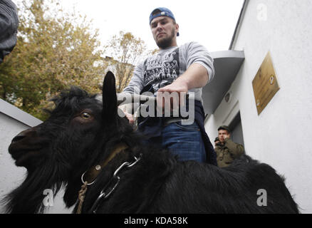 Kiev, Ucraina. 12 ottobre 2017. Gli attivisti ucraini del partito ucraino di estrema destra Nazionale del Corpus ucraino tengono una capra durante una protesta nei pressi dell'ambasciata della Repubblica Ceca a Kiev, Ucraina, il 12 ottobre 2017.il presidente Milos Zeman, che ha parlato a Strasburgo, Francia, il 10 ottobre, ha ribadito la sua posizione contro le sanzioni dell'Unione europea contro la Russia per la crisi Ucraina. La parola ''Kozel'' che significa capra in ucraino è spesso usata per insultare una persona. Crediti: ZUMA Press, Inc./Alamy Live News Foto Stock