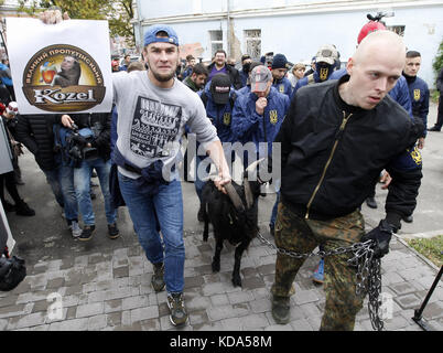 Kiev, Ucraina. 12 ottobre 2017. Gli attivisti ucraini del partito ucraino di estrema destra del Corpus Nazionale hanno un poster con l'immagine del logo di una popolare marca di birra ceca ''Kozel'' e uno slogan che recita: ''un grande pro-Putin Kozel''' e un ritratto del presidente ceco Milos Zeman invece di una testa di capra durante una protesta vicino all'ambasciata della Repubblica Ceca a Kiev, Ucraina, il 12 ottobre 2017.il presidente Zeman che ha parlato a Strasburgo, Francia, il 10 ottobre, ha ribadito la sua posizione contro le sanzioni dell'Unione europea contro la Russia a causa della crisi Ucraina. Crediti: ZUMA Press, Inc./Alamy Live News Foto Stock