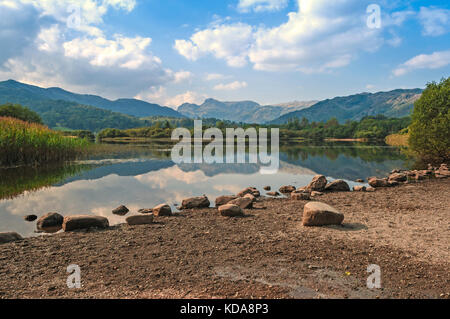 Ancora, lago calmo, mirroring riflessioni di montagna , elterwater con langdale pikes , Lake District inglese Foto Stock