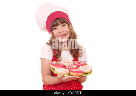 Felice bambina cook con ciambelle sulla piastra Foto Stock