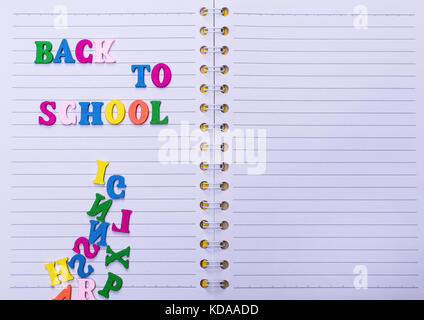 Iscrizione torna a scuola su un notebook bianco in una linea Foto Stock