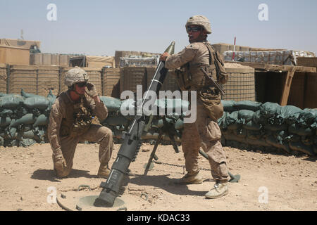 Us marine corps soldati inserire turni in un 120mm mortaio arma durante una missione di addestramento a camp shorab giugno 23, 2017 vicino a lashkar gah, provincia di Helmand, Afghanistan. Foto Stock