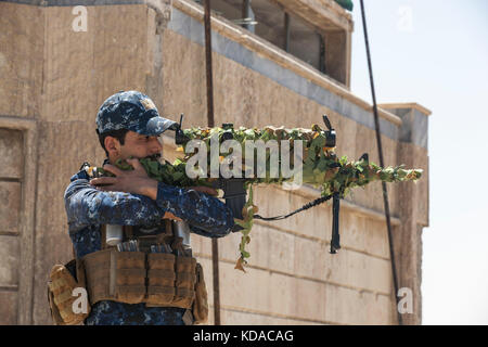 Un iracheno polizia federale sniper guarda attraverso la portata del suo fucile sul tetto di una patrol base giugno 29, 2017 a Mosul, Iraq. vi è stato uno sforzo combinato tra gli Stati Uniti e le forze irachene nella zona per sconfiggere gli estremisti di ISIS. Foto Stock