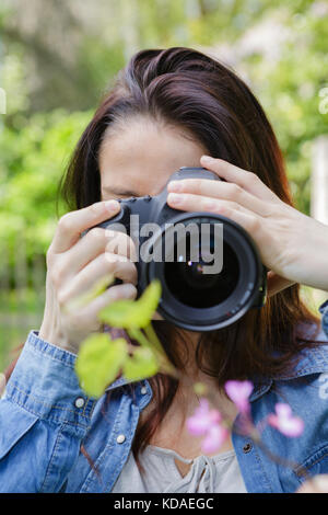 Donna di scattare una foto in natura Foto Stock