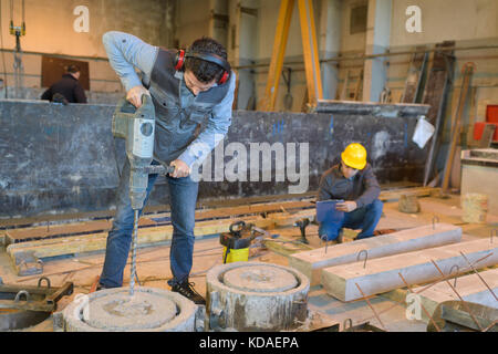 Lavorando con cemento in un magazzino Foto Stock