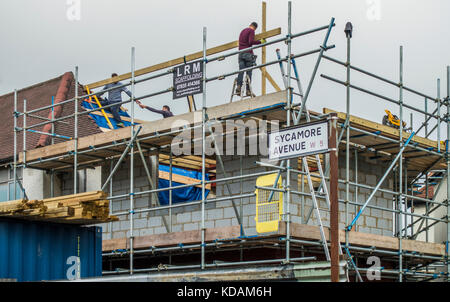 I costruttori, circondato da impalcature, lavorando sul piano superiore di un edificio di due piani corner house estensione, nel South Ealing, West London W5, Inghilterra, Regno Unito. Foto Stock