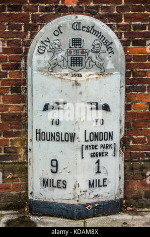 Old City of Westminster pietra miliare nella necessità di riverniciatura, che mostra la distanza da Hyde Park Corner e Hounslow, a Kensington, Londra, Inghilterra, Regno Unito. Foto Stock