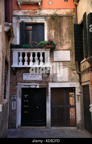 Il percorso stretto tra case e palazzi di Venezia con le indicazioni per San Marco e Rialto, Italia Foto Stock