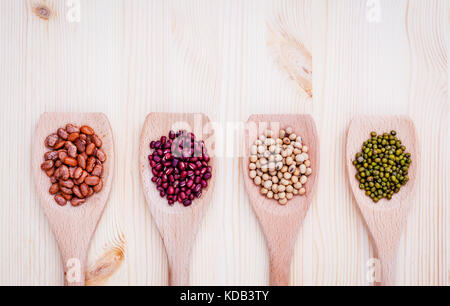 Assortimento di fagioli e lenticchie in cucchiaio di legno su sfondo di legno. semi di soia, Mung bean , Fagiolo rosso e marrone fagioli pinto . Foto Stock