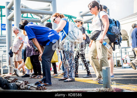 Turisti e locale thailandese persone il pendolarismo sbarcare e a bordo del traghetto che corre il fiume Chao Phraya a Bangkok in Tailandia. Foto Stock