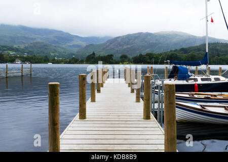 Un pontile sul coniston water su una nebbia e foschia mattutina a Coniston, Cumbria, Regno Unito. Foto Stock