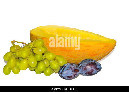 Freschi maturi frutti dolci e bacche: metà di melone, susine e uva verde isolato su uno sfondo bianco - Concetto di vitamine naturali e sani nutrit Foto Stock