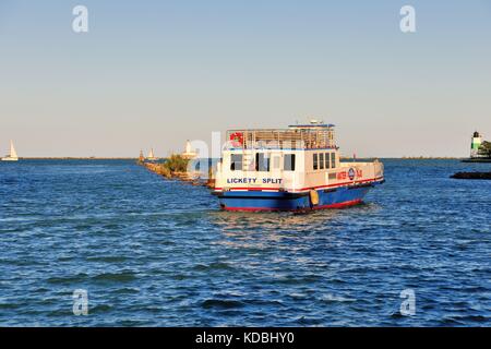 Con un taxi acqueo è evidenziata dal sole di setting come vele lontano da Chicago il Navy Pier nel porto di Chicago. Chicago, Illinois, Stati Uniti d'America. Foto Stock