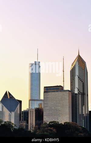 Una porzione sullo skyline di Chicago al di sopra delle estremità nord del Millennium Park si crogiola nel bagliore del sole del tardo pomeriggio. Chicago, Illinois, Stati Uniti d'America. Foto Stock