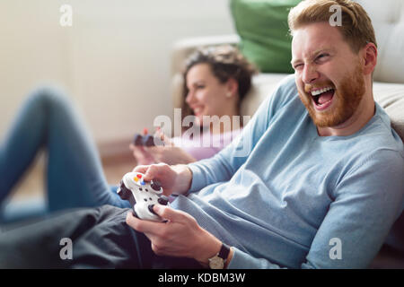 Coppia felice la riproduzione di video giochi a casa Foto Stock