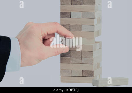 La torre da blocchi di legno e di mano d'uomo prendere un blocco Foto Stock