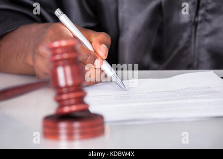 Close-up di un maschio di giudicare la scrittura su carta nelle aule di tribunale Foto Stock