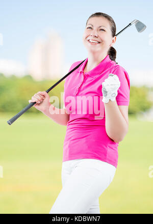 Donna allegra golfista si gode la sua vittoria su uno sfondo di campi da golf Foto Stock