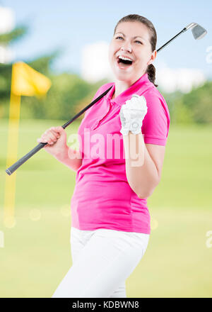 Felice golfista giubilanti su uno sfondo di campi da golf con un club di golf Foto Stock