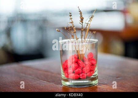 Vetro decorativo vaso con pietre colorate e fiori secchi close-up Foto Stock