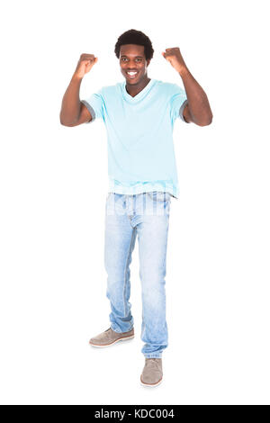 Emozionato casual giovane africano stringendo il pugno isolate su sfondo bianco Foto Stock
