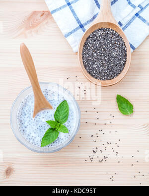 Nutrienti semi di chia in recipiente di vetro con il cucchiaio di legno per la dieta degli ingredienti alimentari setup su sfondo di legno . Foto Stock