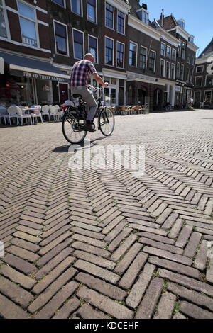 Pavimentazione in mattoni rossi con motivo a spina di pesce nella piazza pedonale del mercato di Delft. Foto Stock