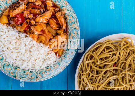 Stile cantonese dolce e aspro di pollo con riso bianco bollito su un blu backgorund in legno Foto Stock