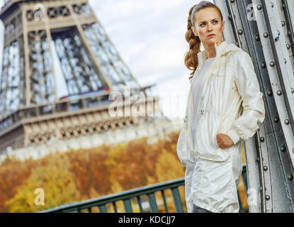 Anno fit & hip a Parigi. giovane donna fitness contro la Torre Eiffel a Parigi cercando la distanza Foto Stock