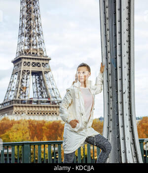 Anno fit & hip a Parigi. giovani montare donna contro la Torre Eiffel a Parigi cercando la distanza Foto Stock