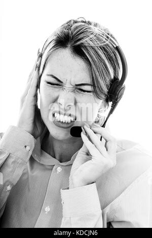 Frustrato ha sottolineato la donna parlando a un client utilizzando una cuffia telefonica clenching i suoi denti in collera con gli occhi chiusi Foto Stock