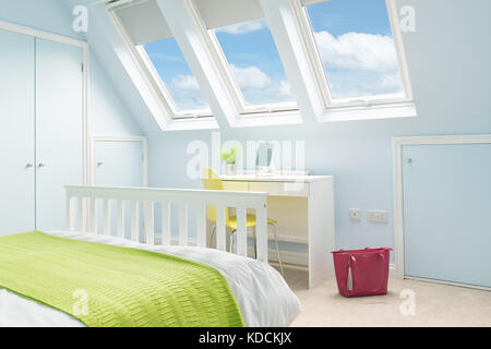 Una luminosa e fresca la camera da letto in una conversione loft con letto doppio, arredamento moderno e lucernario velux windows. Foto Stock