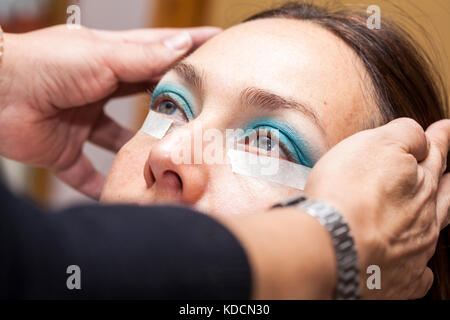 Make up Artist usando del nastro adesivo protettivo per la creazione di occhi di gatto Foto Stock