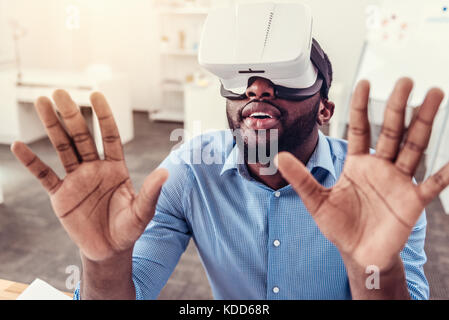 Stupiti giovane godendo di occhiali per realtà virtuale Foto Stock