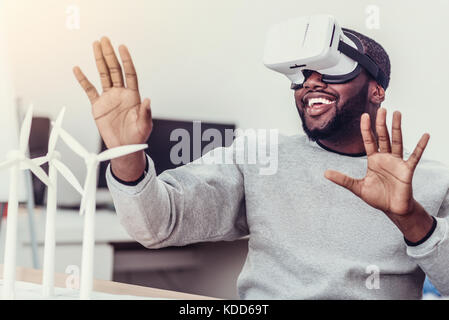 Emotional African American guy godendo di occhiali per realtà virtuale Foto Stock