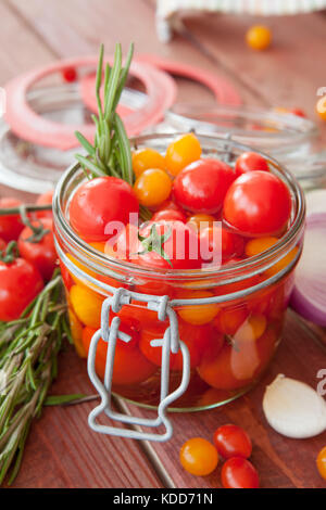 Il decapaggio di pomodori freschi con rosmarino e aglio Foto Stock