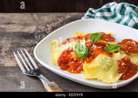 Ravioli con salsa di pomodoro e basilico sul tavolo di legno Foto Stock