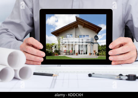 Close-up di architetto mostra un'immagine di casa sulla tavoletta digitale Foto Stock