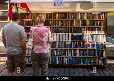 Dordrecht, Paesi Bassi - 7 luglio 2013: matura in piedi in un libro in stallo decidere cosa acquistare presso il libro annuale mercato detenuto nel centro di Dordrecht. Foto Stock
