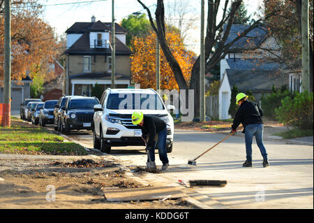 Volontari spazzare la strada al di fuori di un edificio sito a Londra, Ontario in Canada. Foto Stock